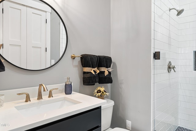 bathroom with toilet, a stall shower, and vanity