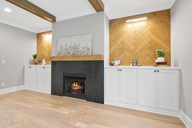 unfurnished living room with beamed ceiling, baseboards, and a tile fireplace