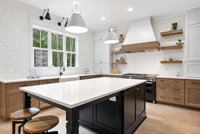 kitchen featuring premium range hood, open shelves, high end stainless steel range oven, a center island, and light countertops