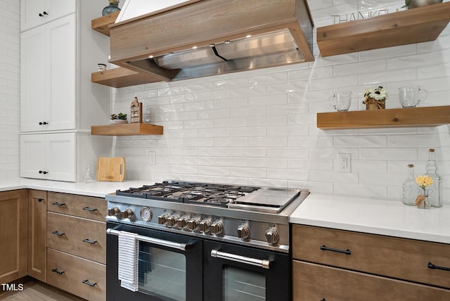 kitchen featuring open shelves, double oven range, backsplash, and premium range hood