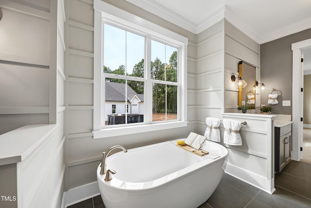 full bath featuring tile patterned floors, a freestanding tub, plenty of natural light, and ornamental molding