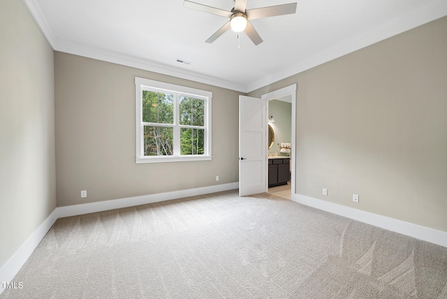 unfurnished room with visible vents, baseboards, light colored carpet, and crown molding