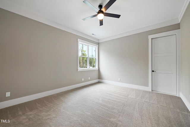 carpeted spare room featuring visible vents, baseboards, a ceiling fan, and crown molding