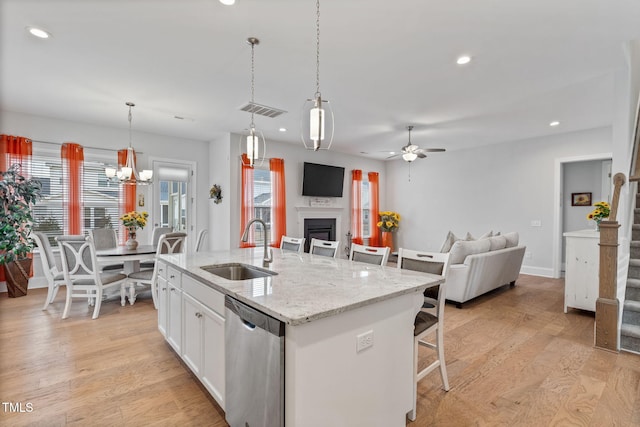 kitchen with open floor plan, a sink, visible vents, and stainless steel dishwasher