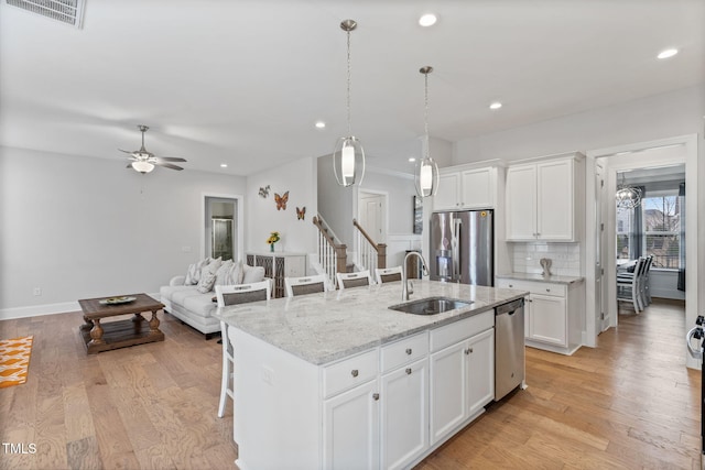 kitchen with a sink, visible vents, light wood-type flooring, and appliances with stainless steel finishes