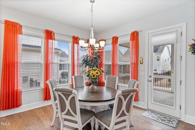 dining space featuring an inviting chandelier, a healthy amount of sunlight, and light wood-type flooring