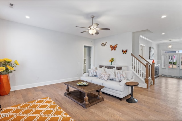 living area featuring stairway, recessed lighting, baseboards, and wood finished floors