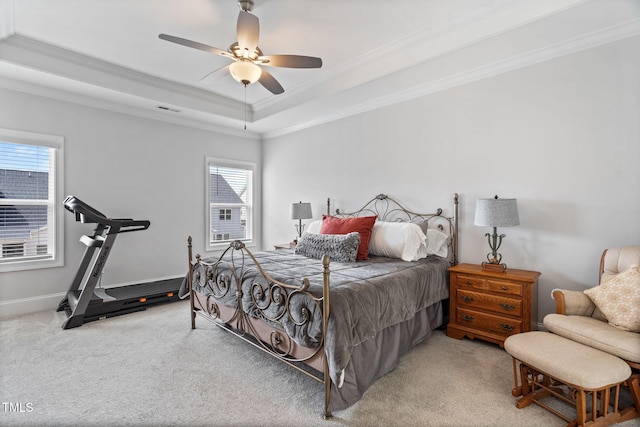 bedroom featuring visible vents, a raised ceiling, crown molding, baseboards, and light colored carpet