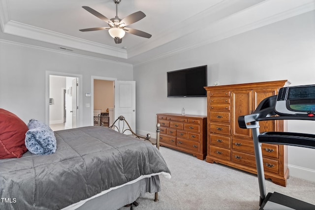 bedroom with ornamental molding, a tray ceiling, and carpet floors