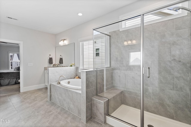 full bath with a wealth of natural light, visible vents, connected bathroom, and a garden tub