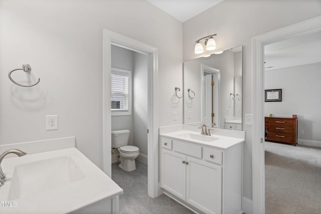 bathroom featuring vanity, toilet, and baseboards