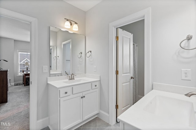 bathroom with two vanities, baseboards, and a sink