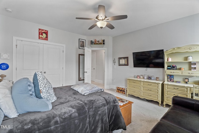 bedroom with a closet, light colored carpet, and a ceiling fan