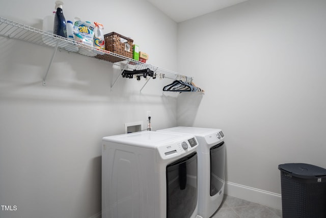 laundry area with laundry area, light tile patterned flooring, baseboards, and washer and clothes dryer