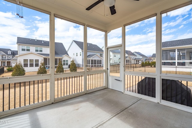 sunroom with a residential view and ceiling fan