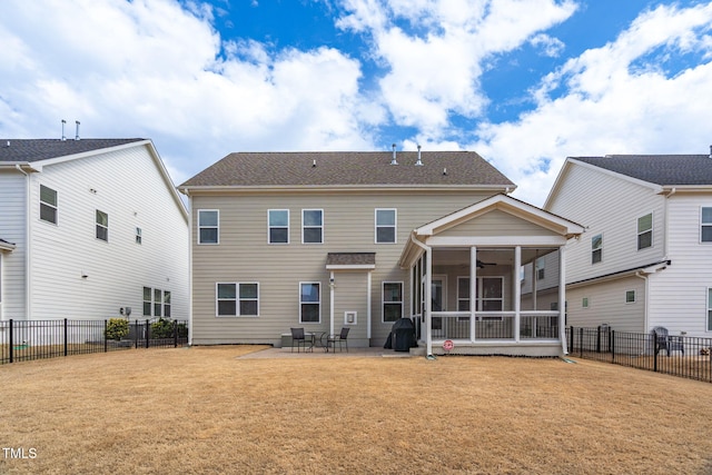 back of house featuring a yard, a patio area, a fenced backyard, and a sunroom