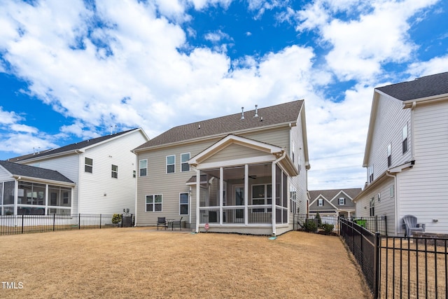 back of house featuring a yard, a fenced backyard, and a sunroom