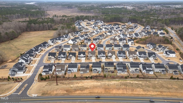 drone / aerial view featuring a residential view and a forest view