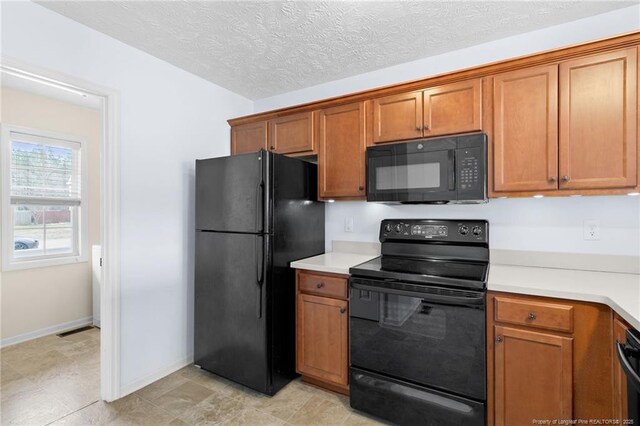 kitchen featuring light countertops, brown cabinets, visible vents, and black appliances