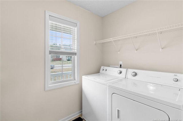 laundry area with laundry area, baseboards, and washing machine and clothes dryer