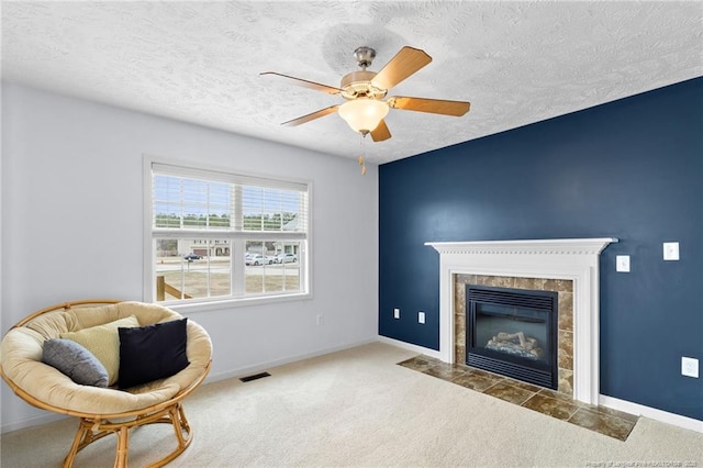 living area with carpet floors, baseboards, a fireplace, and visible vents