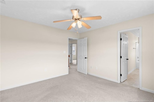 unfurnished room featuring a ceiling fan, light colored carpet, a textured ceiling, and baseboards