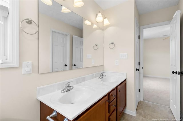 bathroom featuring double vanity, baseboards, and a sink