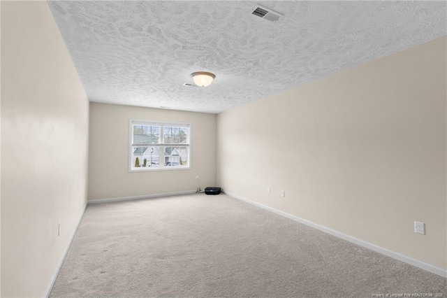 empty room with a textured ceiling, carpet floors, and baseboards