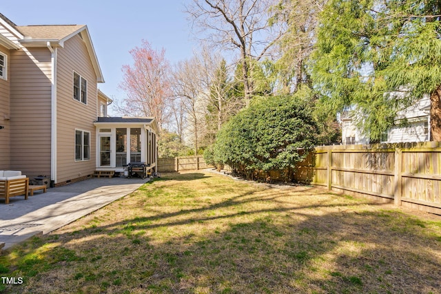 view of yard featuring a sunroom, a patio area, and a fenced backyard