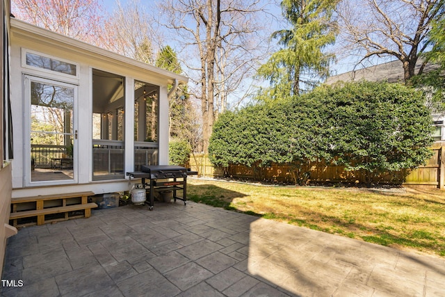 view of patio / terrace with fence, a sunroom, and grilling area