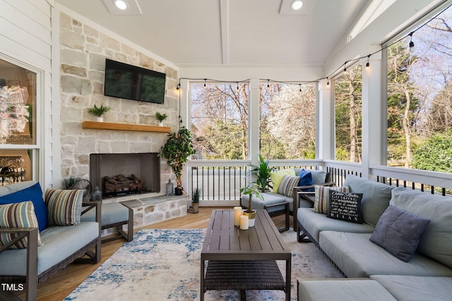 sunroom with a stone fireplace and vaulted ceiling with beams