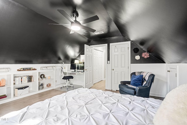 bedroom featuring vaulted ceiling, wood finished floors, visible vents, and ceiling fan