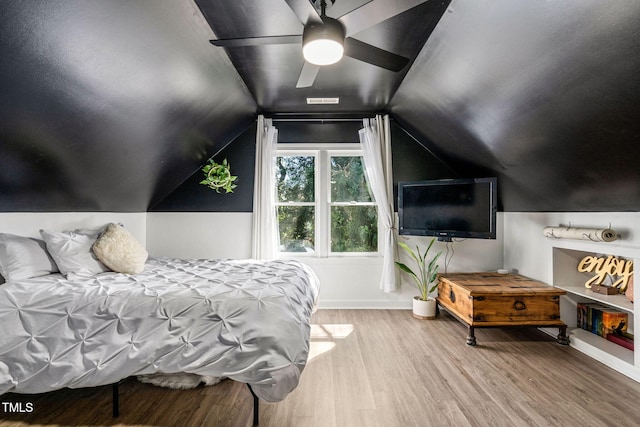 bedroom featuring ceiling fan, visible vents, lofted ceiling, and wood finished floors