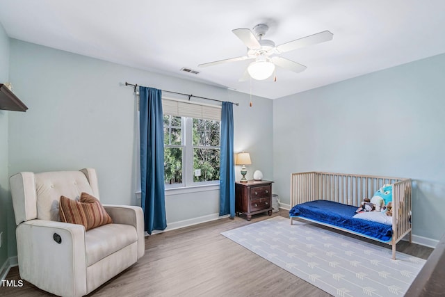 bedroom with visible vents, ceiling fan, baseboards, and wood finished floors