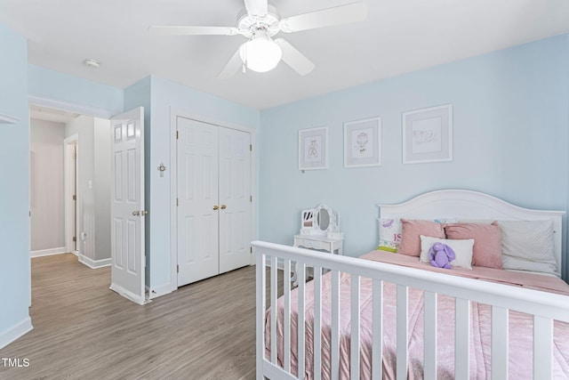 bedroom with a ceiling fan, baseboards, light wood-type flooring, and a closet