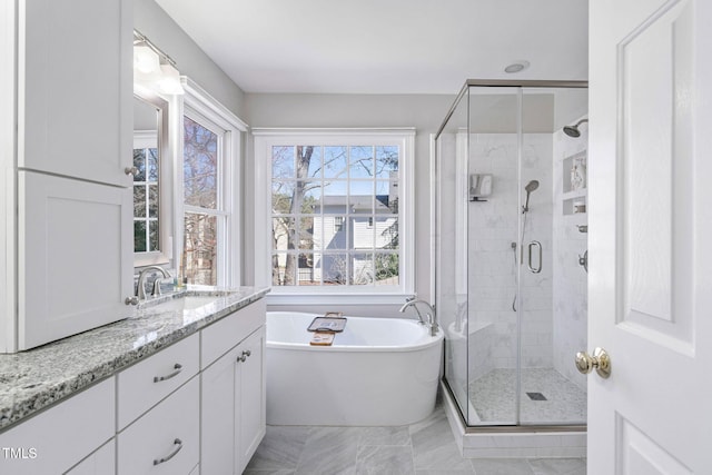 bathroom featuring a shower stall, vanity, marble finish floor, and a freestanding tub