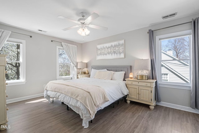 bedroom with visible vents, baseboards, wood finished floors, and a ceiling fan