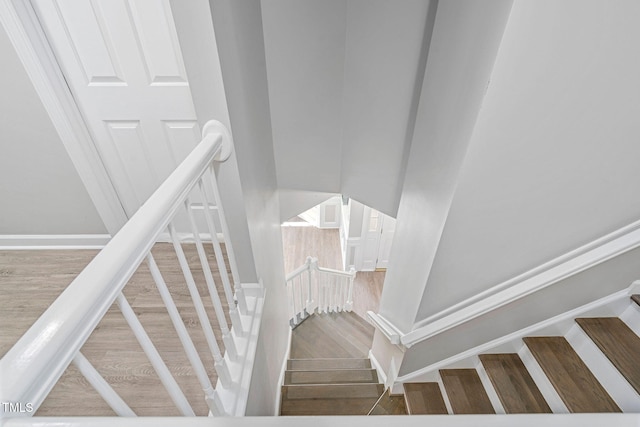 stairway with baseboards and wood finished floors