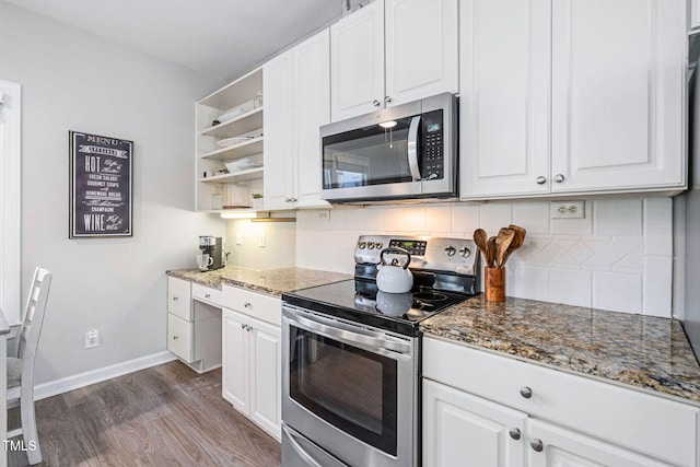 kitchen featuring dark wood-type flooring, tasteful backsplash, white cabinetry, stainless steel appliances, and dark stone counters