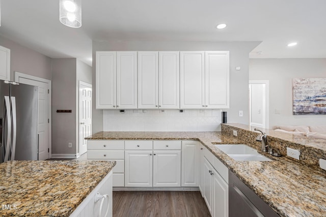 kitchen with light stone counters, dark wood-style flooring, appliances with stainless steel finishes, and a sink