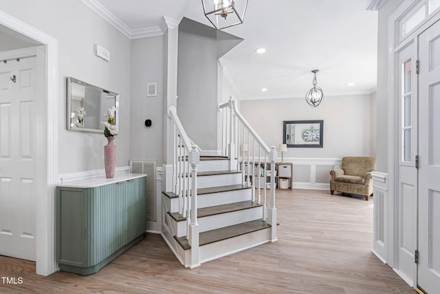 stairway featuring visible vents, a notable chandelier, wood finished floors, and crown molding