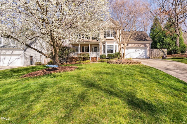 view of front of house featuring a front lawn, an attached garage, and driveway