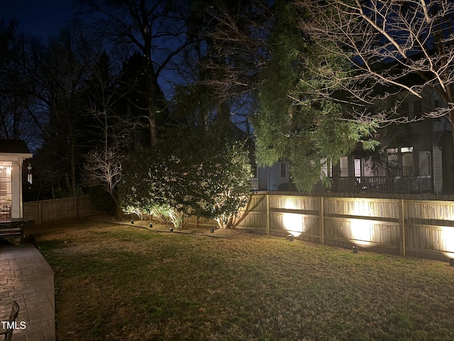 yard at night with a fenced backyard