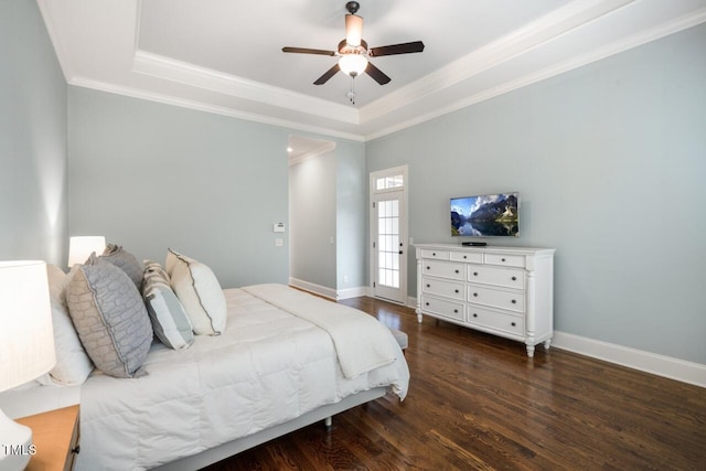 bedroom with wood finished floors, baseboards, a tray ceiling, ceiling fan, and ornamental molding