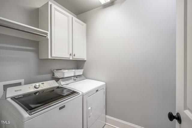 laundry room with cabinet space, washing machine and dryer, and baseboards