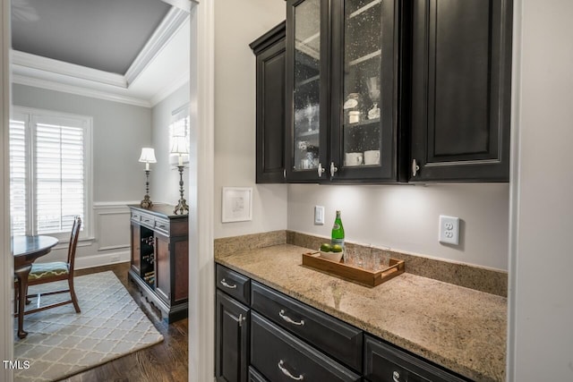 bar featuring a tray ceiling, a healthy amount of sunlight, dark wood-style floors, and crown molding