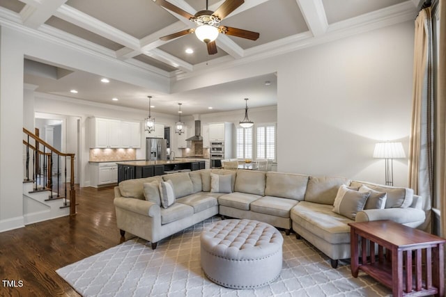 living area with stairway, wood finished floors, beamed ceiling, and coffered ceiling