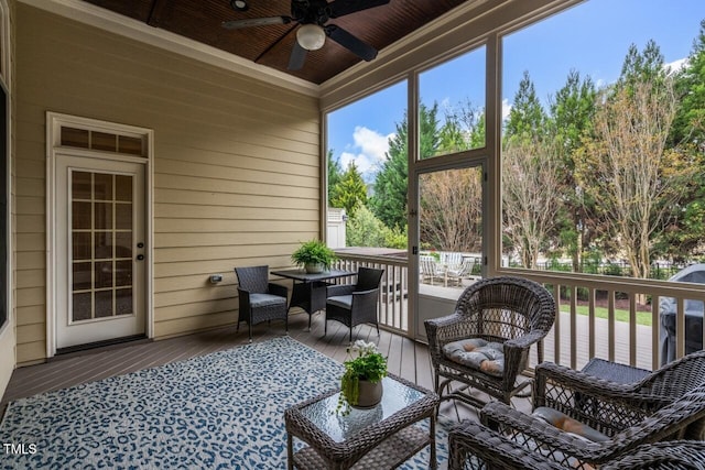 sunroom / solarium featuring wood ceiling and a ceiling fan