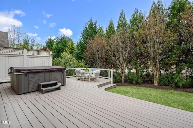 wooden deck with a lawn, a hot tub, and fence