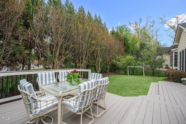 deck featuring outdoor dining space and a yard